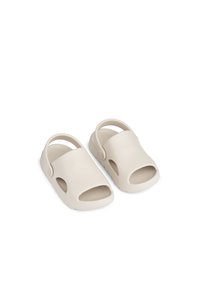 Beige åpne tå-sandaler laget av teksturert gummi, med stropp bak, bred åpning foran og riller under for grep.