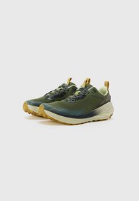 Groene wandelschoenen met een gestructureerde bovenkant, zwarte veters en een gele accent. Beschikt over een robuuste zool met een opvallend profiel.