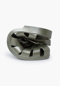 Green plastic product with a curved, twisted design and cut-out sections. Smooth texture with a matte finish. Compact and stackable form.