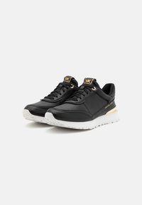 Baskets de sport noires en cuir synthétique avec une semelle en caoutchouc blanc. Présentent des accents dorés et un design à lacets ; logo en relief sur la languette.
