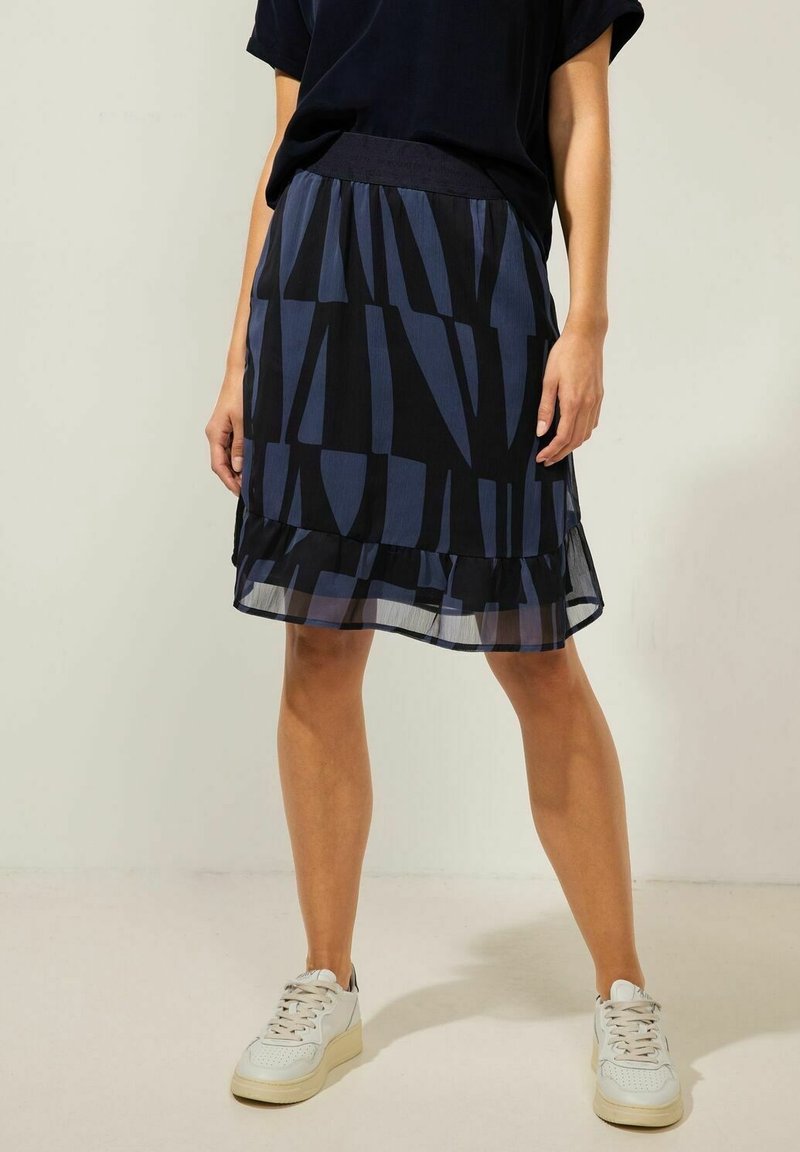 Czarna i niebieska spódnica warstwowa z abstrakcyjnym wzorem, przezroczystą falbaną u dołu, elastycznym pasem i lekką teksturą materiału.