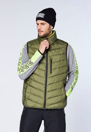 Puffer vest in olive green with quilted texture, side pockets, and a zippered chest pocket. Features gray sleeves with neon green accents.