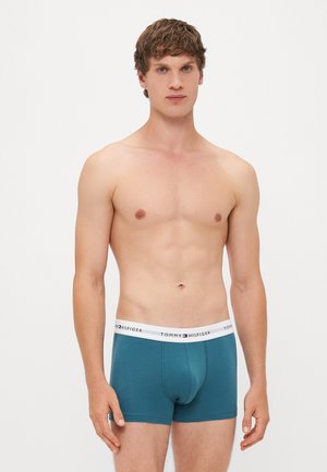 Türkisfarbene Baumwoll-Boxershorts mit einem weißen elastischen Bund, der das "TOMMY HILFIGER"-Logo trägt. Figurbetontes Design mit glatter Textur.