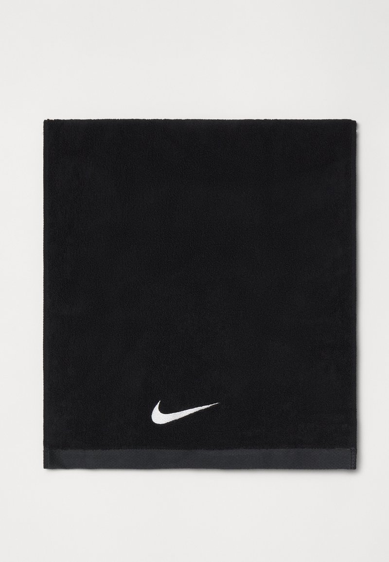 Sort bomuldshåndklæde med en blød tekstur, prydet med et hvidt Nike swoosh-logo i nederste hjørne og en kontrasterende sort kant.
