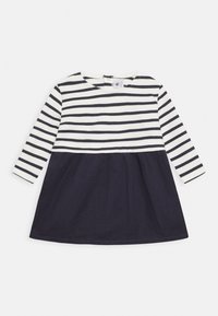 Vestido de manga larga a rayas con un fondo azul marino y una parte superior blanca. La parte superior presenta rayas negras horizontales; la tela es suave y ligera.