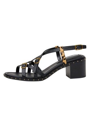 Sandalia negra de tacón con hebillas doradas, tira con estampado de leopardo, borde de la suela con tachuelas y tacón ancho sobre fondo blanco.