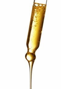 Cuentagotas con vástago y bulbo de vidrio transparente. Contiene un líquido dorado con burbujas, que se estrecha en el extremo. Superficie lisa con acabado brillante.