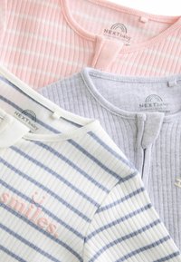 Trois tops en ribbed pour bébé en rose, gris et blanc avec des rayures bleu. Chacun a un col arrondi, une patte de boutonnage et du texte brodé sur l'un d'eux.