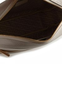 Borsa beige in pelle con esterno strutturato, cerniera dorata e interno marrone decorato. L'interno dispone di scomparti per l'organizzazione.