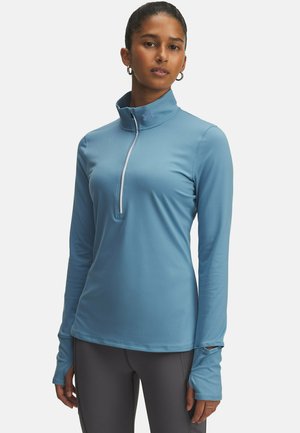 Helles blaues Langarm-Pullover mit einem halben Reißverschluss-Kragen, gefertigt aus einem glatten, dehnbaren Stoff. Verfügt über Daumenlöcher an den Bündchen und ein dezentes Logo-Detail.