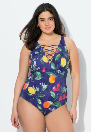 Maillot de bain une pièce violet avec un motif de fruits en jaune, rouge et vert. Comprend un décolleté en V profond et un détail en dentelle entrecroisée à l'avant.