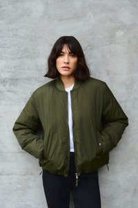 Oliivroheline bomber-jakk, millel on lõhik ning soonikkoes krae ja elastsed mansetid. Kandmiseks valge särgi ja mustade pükstega. Sile tekstuur.