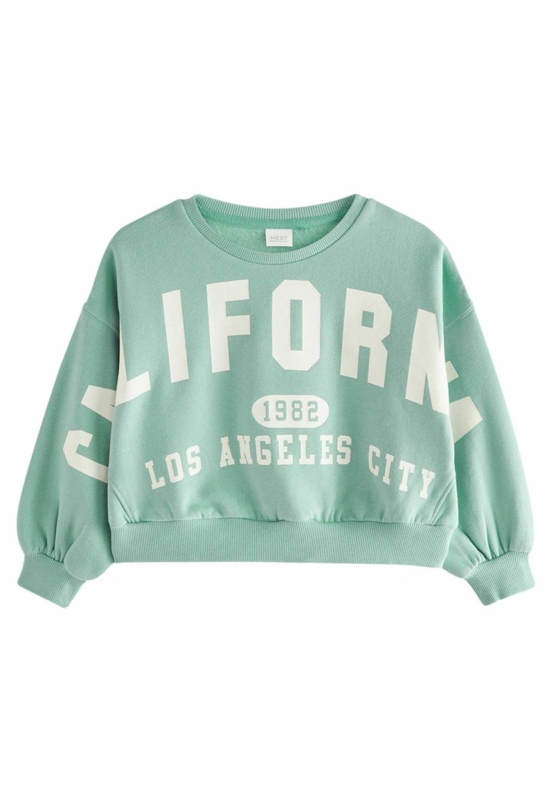 Sweat-shirt court vert menthe avec des manches bouffantes, des poignets côtelés et un texte blanc indiquant "CALIFORNIA 1982 LOS ANGELES CITY" sur le devant.