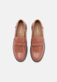 Bruna lackläders loafers med dekorativ rosett och rund tå. Har en vadderad insida och en hållbar sula.