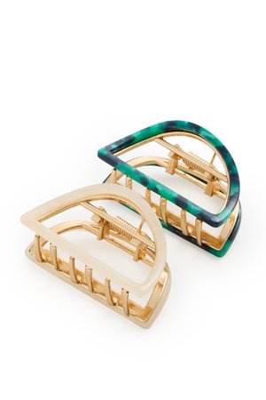 Dos clips de cabello geométricos en forma de medio círculo con dientes metálicos dorados; un clip tiene bordes verdes y negros con efecto mármol, el otro es de color crema.