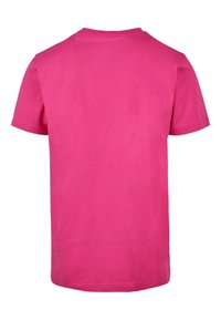 T-shirt a manica corta in cotone rosa brillante con collo rotondo e colore uniforme. Texture morbida, senza motivi visibili o dettagli hardware.
