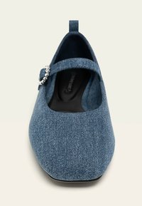 Bailarina de denim con punta redondeada, tira tipo Mary Jane y un acento decorativo de hebilla de cristal. Tela suave y plantilla acolchada para mayor comodidad.
