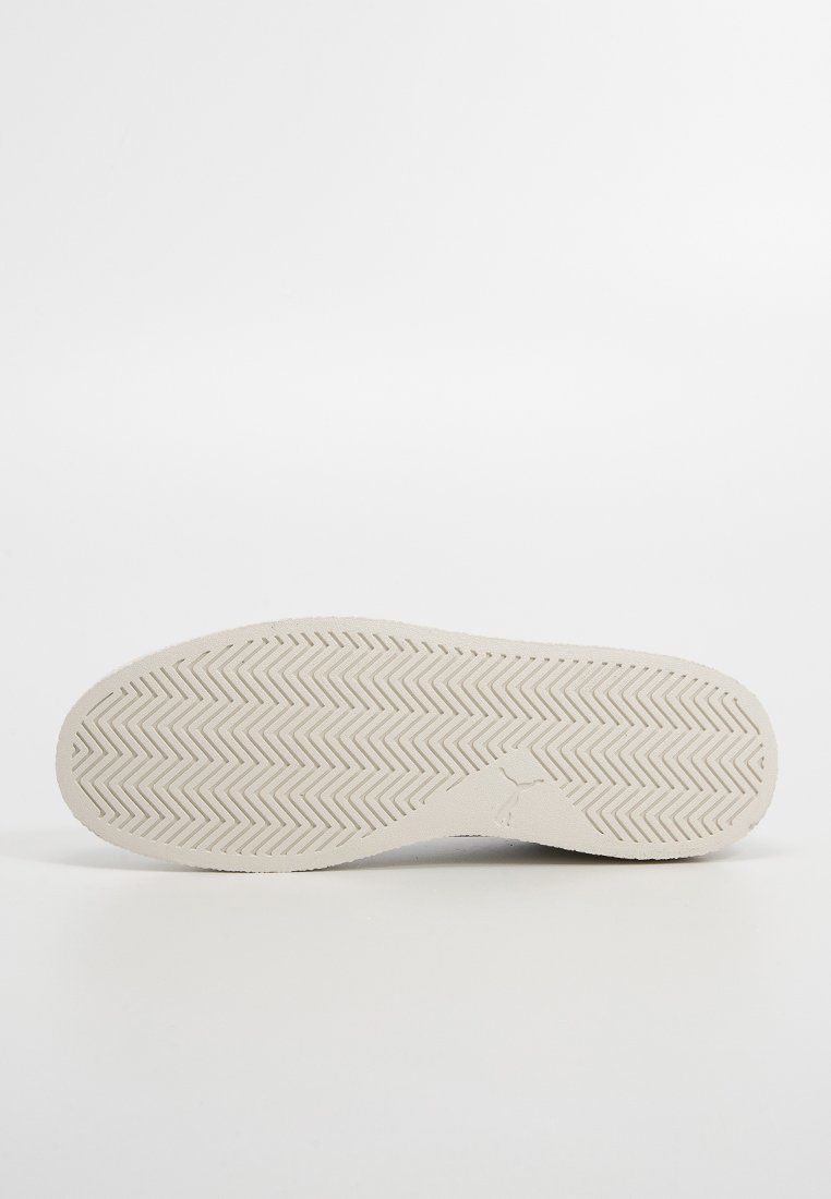 Podeszwa sneakersów w off-white gumie z zygzakowatym wzorem bieżnika i centralnym detalem logo, gładka faktura i zaokrąglone krawędzie.