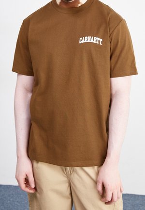 T-shirt en coton marron à manches courtes et col rond, arborant un logo texte "CARHARTT" blanc sur la zone gauche de la poitrine.