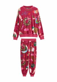 Red Christmas pajama set with wreaths, stockings, polar bears, desserts, and festive text patterns on sweatshirt and pants.