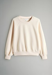 Lichtbeige sweatshirt met een ronde hals, raglanmouwen en geribbelde manchetten. De stof heeft een zachte textuur en een gezellige uitstraling.
