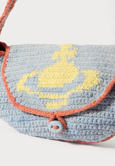 Gaiši zilas tamborētas somas ar dzeltenu rakstu. Tai ir korāļkrāsas apdare un aizdare ar pogu. Auduma dizains ar tekstūru.