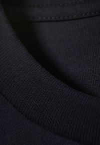Marineblauwe katoenen sweatshirt met een ribbeltextuur, een gladde oppervlakte en zichtbare stiksels.