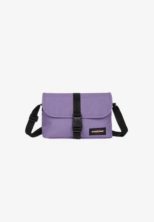 Paarse stoffen schoudertas met een flapsluiting, zwarte gesp en verstelbare riem. Voorzien van een Eastpak-logopatch aan de voorkant.
