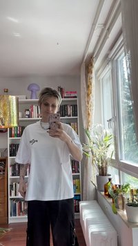 Hvid oversized t-shirt med "Paper" trykt i sort på venstre side. Korte ærmer, lavet af bomuld, og parret med sorte cargo bukser.