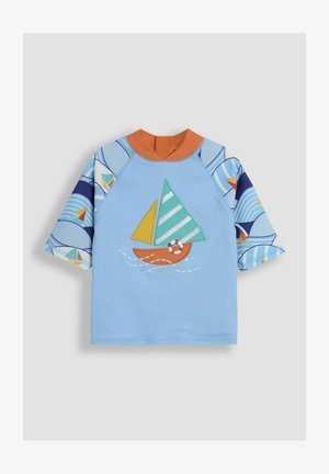 Světle modrý dětský rash guard s oranžovým límcem. Obsahuje aplikaci plachetnice se zelenými a žlutými plachtami; rukávy ukazují námořnické vzory.