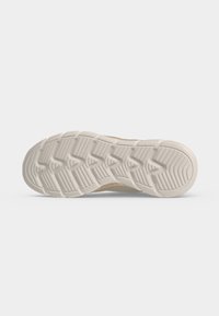 Semelle d'une chaussure marron clair avec un motif de bande de roulement épais et blanc comportant des rainures horizontales et en forme de chevrons pour l'adhérence.