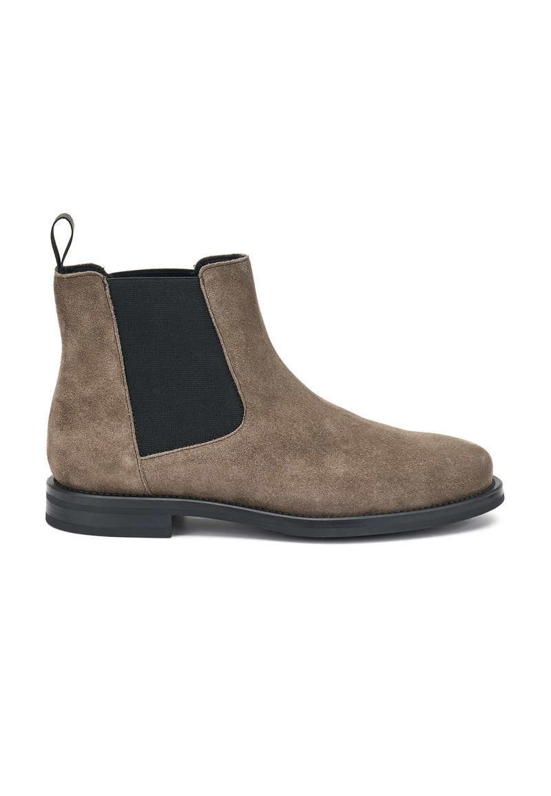 Botas Chelsea de ante marrón con paneles laterales elásticos, acabado texturizado y suela de goma negra. Incluyen una cinta de tirón para facilitar su uso.