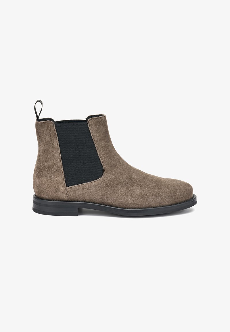 Botas Chelsea de ante marrón con paneles laterales elásticos, acabado texturizado y suela de goma negra. Incluyen una cinta de tirón para facilitar su uso.