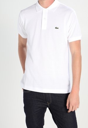 White short-sleeve polo shirt made of cotton, featuring a two-button placket and a small green crocodile logo on the left chest.