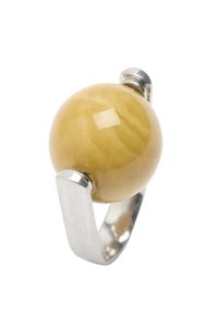 Srebrny pierścionek z szeroką obrączką, trzymający duż�ą, gładką, okrągłą musztardowo-żółtą kamień osadzony na białym tle.