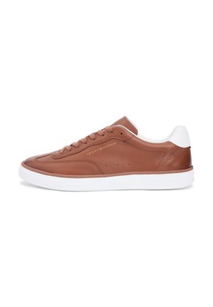 Baskets basses en cuir marron avec semelle blanche et languette au talon, design à lacets et logo "Tommy Hilfiger" sur le côté.