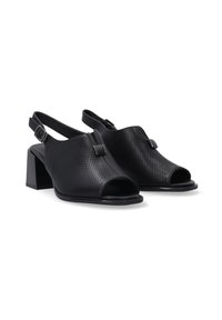 Černé otevřené slingback boty z perforované kůže s blokovým podpatkem. Mají pásek kolem kotníku se kovovou sponou pro nastavení.