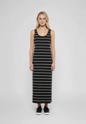 Robe maxi rayée avec des rayures verticales noires et blanches, sans manches et à coupe décontractée, associée à des baskets noires à lacets.