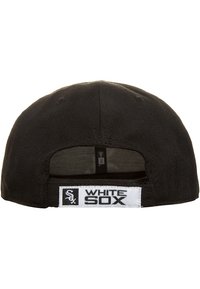 Musta baseball-lippalakki, jossa säädettävä remmi. Valkoinen etiketti, jossa lukee "WHITE SOX" ja logo. Puuvillamateriaalia, jämäkkä rakenne.