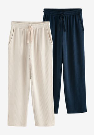 Två par ribbade loungbyxor: en i krämfärg med beige ränder, en i marinblå. Båda har elastiska midjeband och sidofickor.