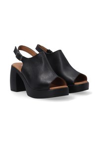 Zwarte open teen platform sandalen met een leren bovenwerk met textuur, brede gespband en chunky hak. Bruin leren binnenzool.