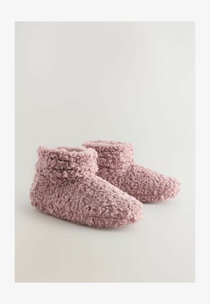 Lyserøde, fuzzy støvleslipper med en tekstureret overflade og en høj skaft. Blødt materiale omslutter foden for varme og komfort.