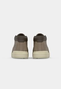 Bruine suède hoogtop sneakers hebben een gladde textuur, afgeronde neus en een lichtgekleurde rubberen zool. Subtiel logo aan de zijkant.