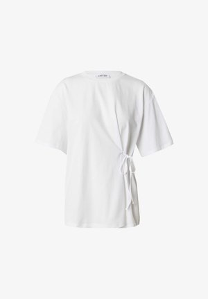 White cotton t-shirt featuring a round neckline, short sleeves, and a side tie detail for adjustment. Smooth texture with a relaxed fit.