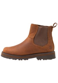 Bottine en cuir marron avec des panneaux latéraux en élastique, une languette de traction, une semelle robuste et une semelle en caoutchouc marron contrastée. Logo discret embossé sur le côté.