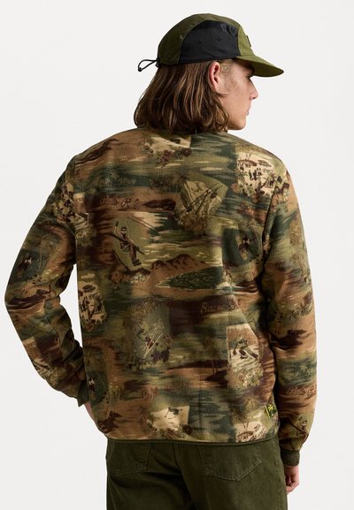 Camo sweater in shades of green and brown with textured fabric, featuring outdoor-themed patterns. Ribbed cuffs and hem.