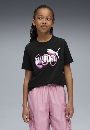 T-shirt nera in cotone con un audace logo grafico rosa e bianco, abbinata a pantaloni corti larghi rosa chiaro con tasche laterali e cintura elastica.
