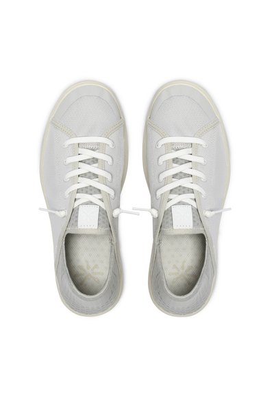 Par de zapatos casuales de cordones color gris claro con suelas blancas y tejido de malla, vistos desde arriba sobre un fondo blanco liso.