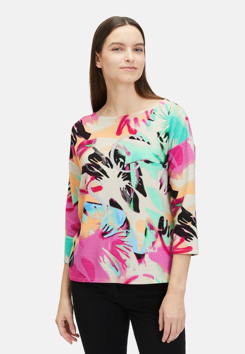 Multicolored long-sleeve top featuring a floral pattern with shades of pink, turquoise, and black, made from a textured fabric.