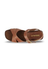 Sandale en cuir marron avec des brides croisées, une semelle en bois et un détail de boucle métallique. Texture lisse et finition en bois naturel.
